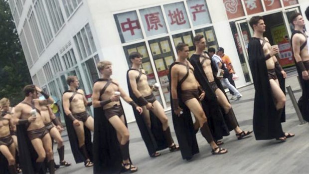 A salad restaurant paraded dozens of half-naked Western men dressed as Spartans through China's capital as a publicity stunt, causing a stir and drawing a crackdown by police.