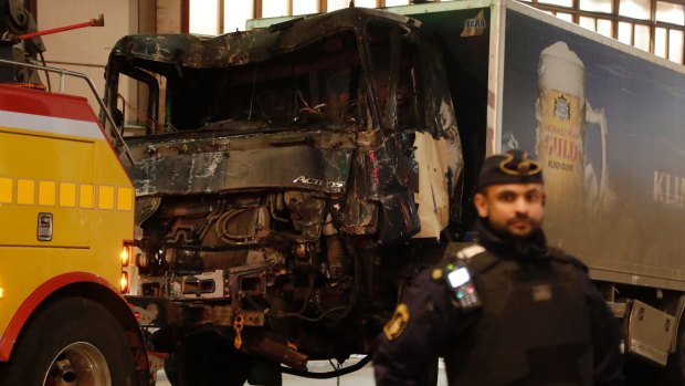 A destroyed truck is pull away by a service car after it was driven into a department store in Stockholm, Sweden.