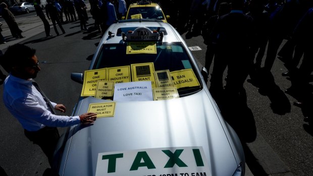 Taxi drivers protesting over Uber at Parliament House. Victoria's Taxi Services Commission says it has issued 355 infringement notices to uberX drivers.