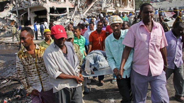 Somalis remove the body of a man killed in Saturday's blast, in Mogadishu.