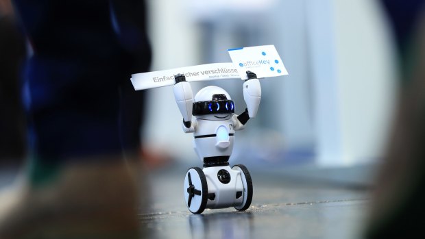 A tiny WowWee Group Ltd. Coder MiP programmable balance robot carries company business cards in Hannover, Germany.
