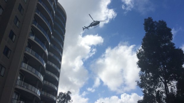 A police helicopter flies over a crime scene set up at the Monarco Estate complex in Westmead after a woman's body was found nearby.