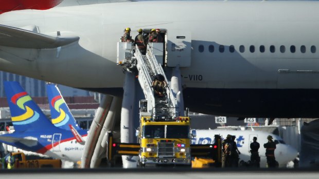 Firefighters enter a plane that caught fire at McCarren International Airport in Las Vegas.  
