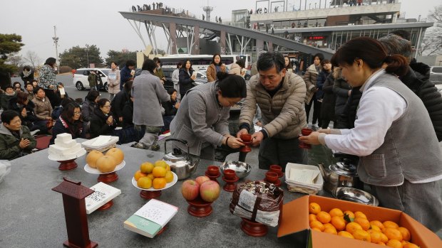 A Buddhist man offers wine to a woman during a January 1 service on the Korean peninsula at Imjingak to wish for peace and reunification.