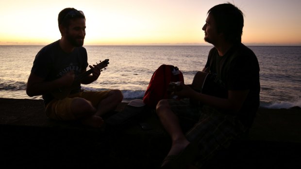 Friends Marc Mnemosyne (right) and Ben Vodinh, both originally from Reunion Island and now living in Paris, play the guitar and ukulele on Saint-Denis beach, Reunion Island. 