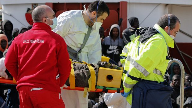 A migrant is helped by Red Cross assistants as he arrives at the Sicilian harbour of Pozzallo on Sunday.