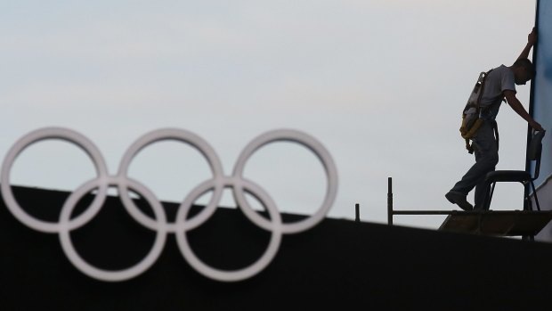 A man works near a display of Olympic rings at the official Olympics megastore on Copacabana beach in Rio de Janeiro.