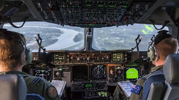 Royal Australian Air Force pilots, Flight Lieutenant Simon Marshall (left) and Flying Officer Jake Nicholas, prepare to land a C-17A in Suva, Fiji, as part of Operation Fiji Assist. 