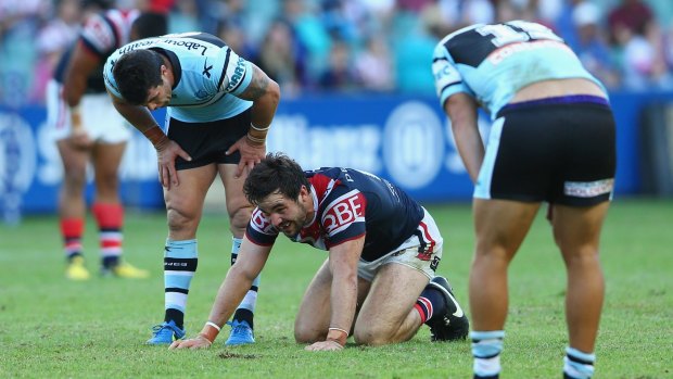 Down and out: Michael Ennis checks on Aidan Guerra after the Rooster suffered a broken jaw.