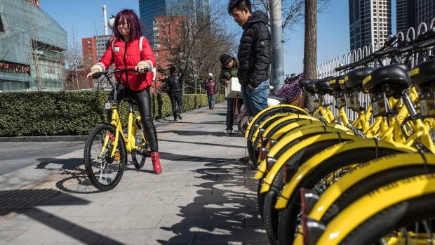Picking up an Ofo bike. Commuters can pick up the bikes, ride them, then drop them off anywhere they like. 