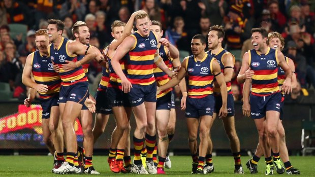 Adelaide players congratulate teammate Reilly O'Brien after he kicked his first goal.