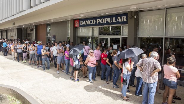 People stand in line to withdraw cash after Hurricane Maria in San Juan, Puerto Rico.