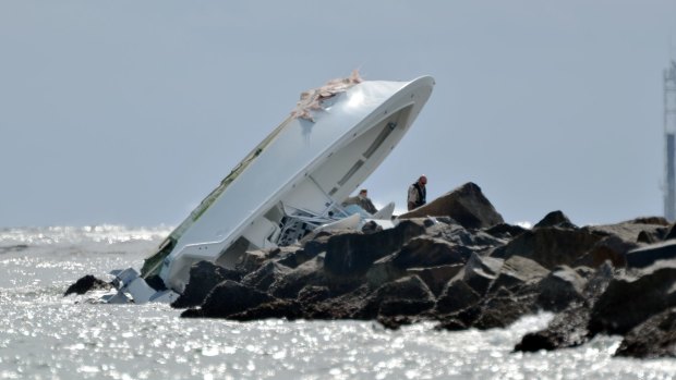 Investigators look at the crashed boat that Fernandez was in.
