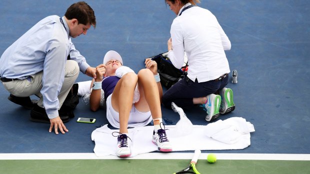 Worrying scenes: Johanna Konta is tended to on the court at Flushing Meadows.