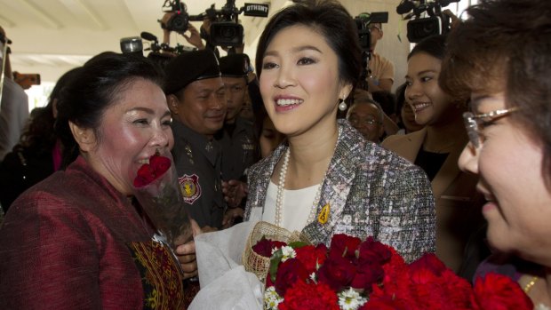 Thailand's former Prime Minister Yingluck Shinawatra receives flowers from her supporters on Thursday.