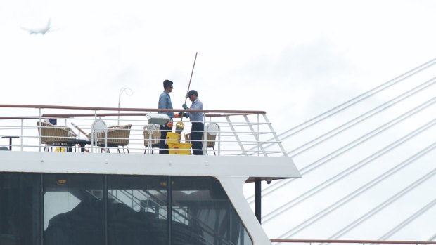 Crew members of the P&O's newly-launched cruise liner Pacific Eden clean and disinfect the ship while docked at the White Bay terminal.