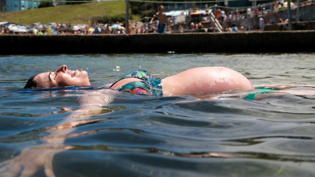 Pregnant Kate Topham takes relief from the hot weather in the rock pool in North Bondi.