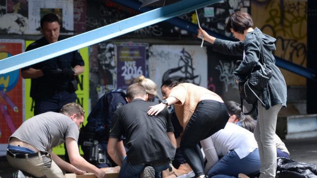 Witnesses help the injured on Bourke Street.