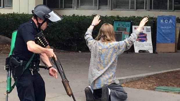 A SWAT officer searches a student who was evacuated from the UCLA campus on the day of the fatal shooting.