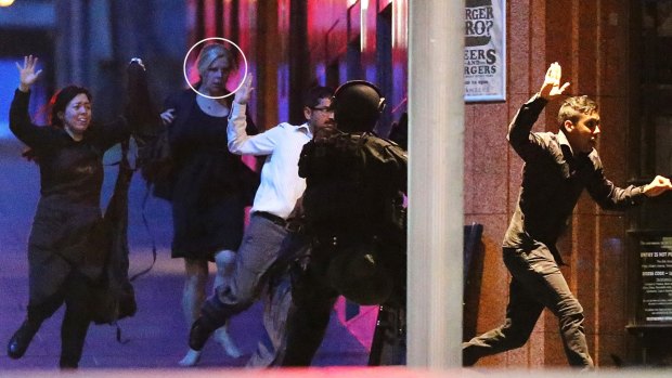 Pregnant Sydney siege survivor Julie Taylor (circled) runs with other hostages from the Lindt cafe in Martin Place.