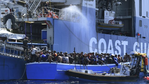 Some of the 441 refugees attempting to cross from Libya to Europe on a wooden boat are rescued by the Swedish Coast Guard off Libya. 