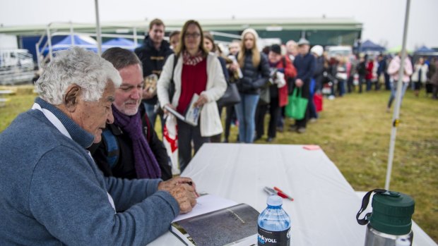 Fans young and old queue to have books signed by Italian chef Antonio Carluccio at the Capital Region Farmers Market in Canberra on Saturday.
