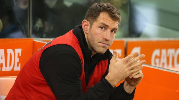 Out of action: Travis Cloke of the Magpies sits injured on the bench with a calf injury.