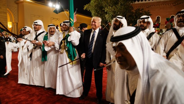 President Donald Trump holds a sword and sways with traditional dancers during a welcome ceremony in Riyadh. 