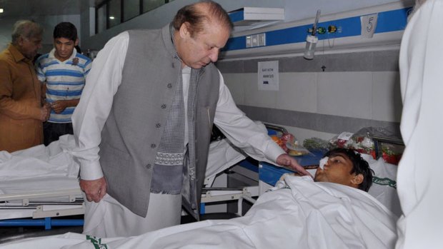Pakistani Prime Minister Nawaz Sharif talks to an injured victim of Sunday's suicide bombing in a hospital in Lahore on Monday.