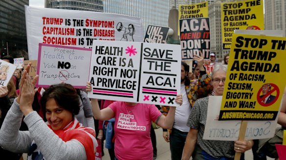 Protesters in Chicago celebrate Donald Trump's defeat on healthcare law repeal.