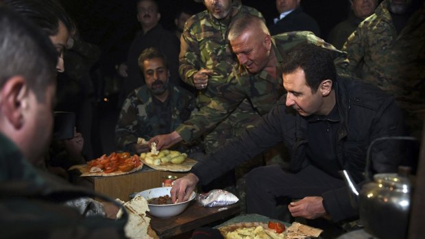 Syrian President Bashar al-Assad, right, eats with soldiers during a visit to Jobar, northeast of Damascus, in this handout photograph distributed by Syria's national news agency SANA on Thursday.