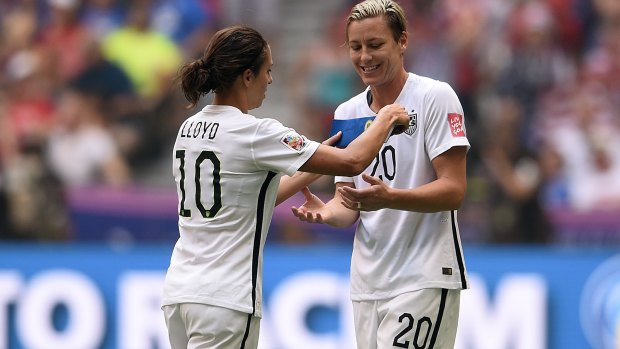 Carli Lloyd (left) gives the captain's armband to teammate Abby Wambach. 