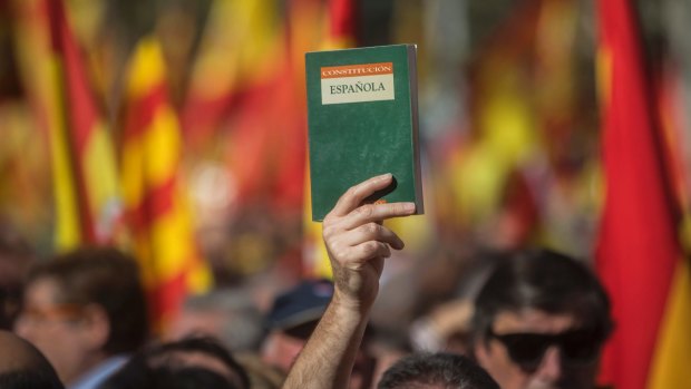 A unionist supporter holds up a copy of the Spanish Constitution in Barcelona on Sunday.