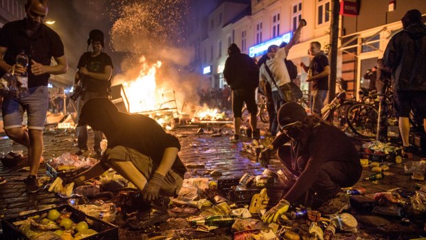 Protesters against the G20 Summit plunder a supermarket and throw the goods into fires in the Schanzenviertel district.