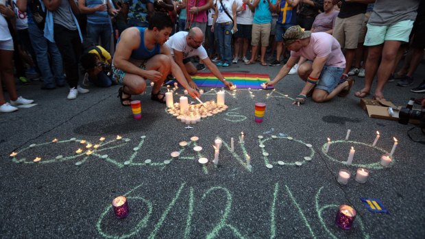 People light candles in a US vigil following the massacre in Orlando.