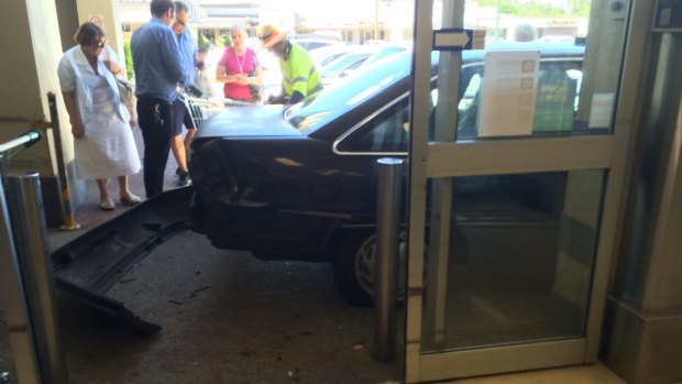 A car has crashed into a shopping complex at Kenmore.