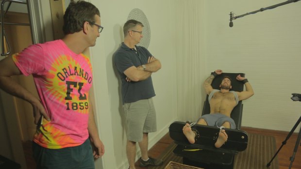 David Farrier (left) watching a scene from his movie <i>Tickled</i>.