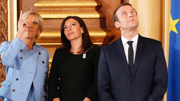 French President Emmanuel Macron, his wife Brigitte, left, and Paris Mayor Anne Hidalgo, centre, on Sunday.
