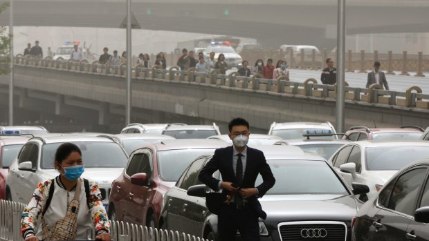 People wear face masks to avoid the pollution in Beijing on Thursday. 