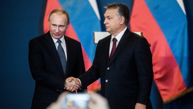 Vladimir Putin and Viktor Orban shake hands in Budapest.