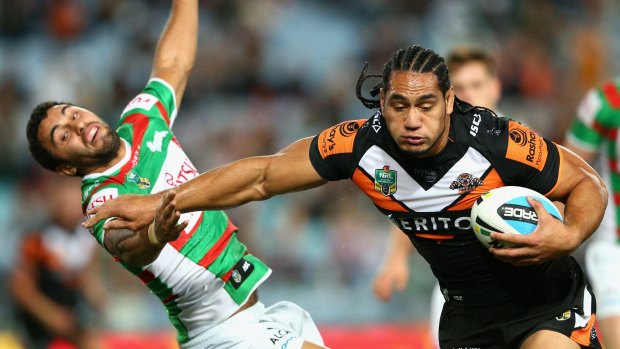Hands off: Martin Taupau of the Tigers sends Souths fullback Alex Johnston flying. 