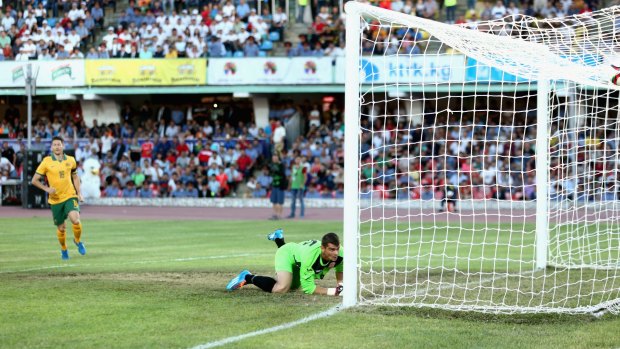 Bad bounce ... Kyrgyzstan goalie Valerii Kashuba fails to stop a free kick by Australian captain Mile Jedinak.