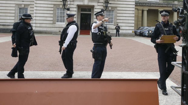 Increased security: Armed police officers work at the main gate of Buckingham Palace in London.
