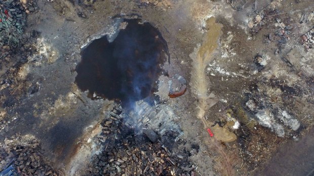 Smoke rises from debris near a crater at the centre of the series of explosions.