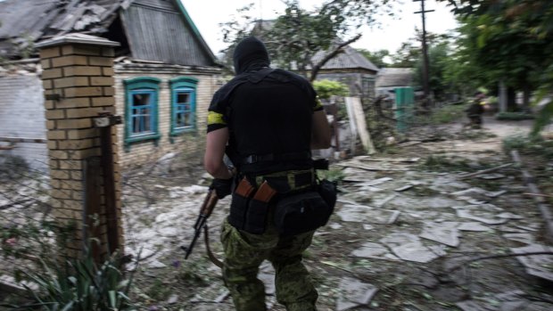 A Ukrainian serviceman from battalion "Kiev1" runs to his position near a damaged house in Marinka, Donetsk region, eastern Ukraine.