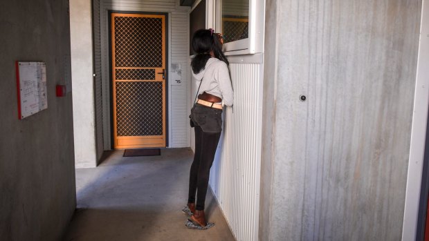 Akiir Muo peers through a window at her boyfriend's mother's home in Windsor. 