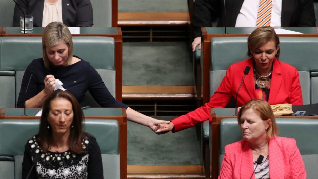 Susan Lamb holds hands with Anne Aly as Opposition Leader Bill Shorten delivered a statement about the death of Linda Burney's son in October.