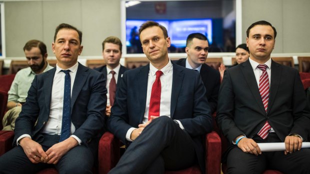 Alexei Navalny, centre, who submitted endorsement papers necessary for his registration as a presidential candidate, centre, waits for the decision.