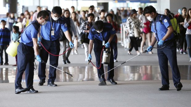 Workers spray antiseptic solution at Incheon International Airport in South Korea on Wednesday.