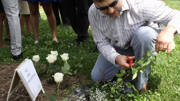Travis Norton, a staffer in the office of Senator Tim Scott, of South Carolina, plants nine roses on the lawn on Capitol Hill in Washington.